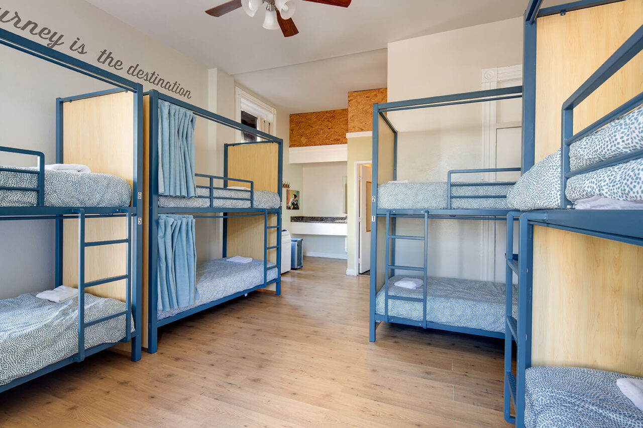 an 8-bed dorm with privacy screens and curtains on each bunk bed and an ensuite bathroom at HI San Diego Downtown hostel