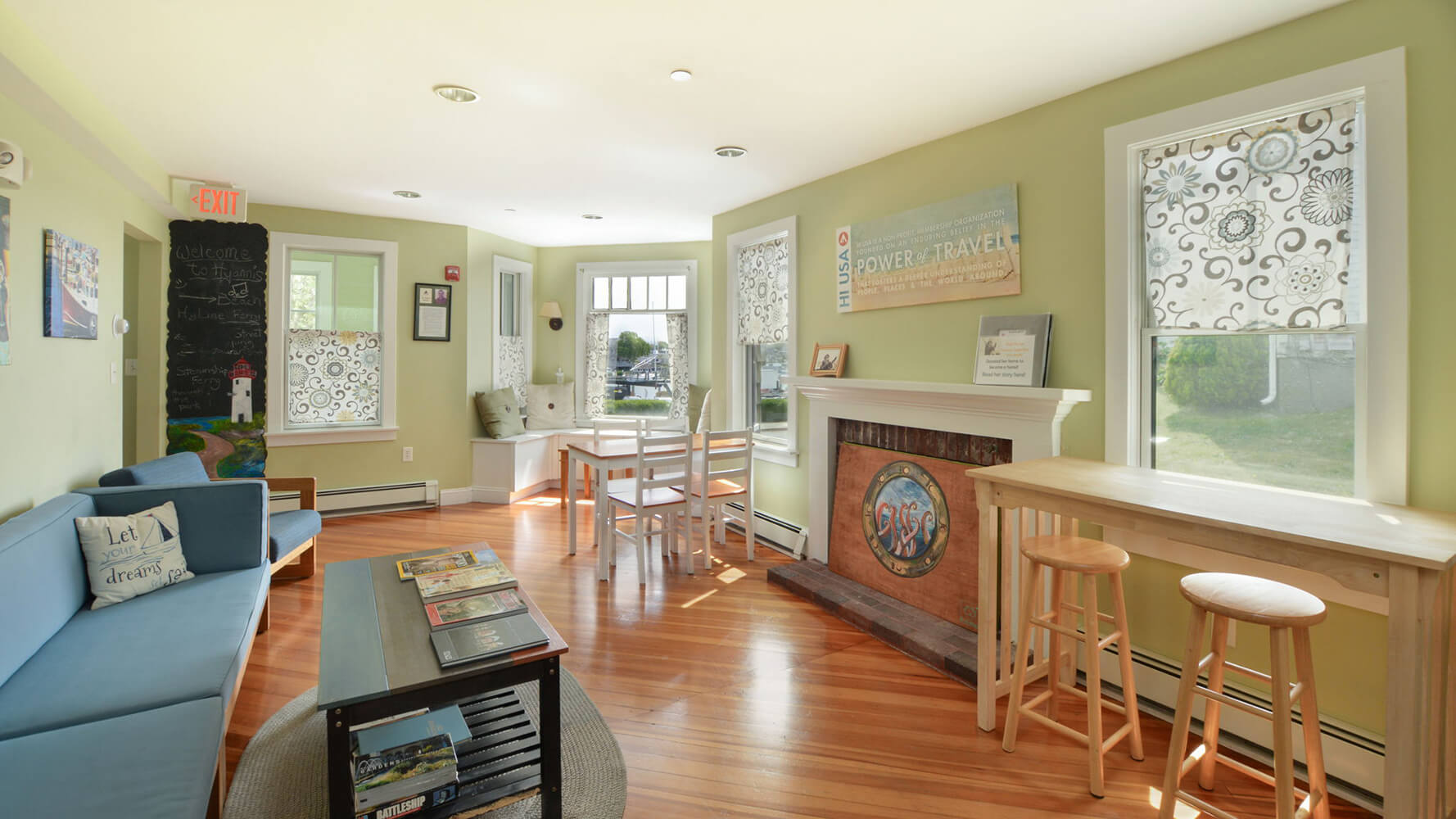 a shared guest lounge at HI Hyannis hostel on Cape Cod with comfortable couches, tables and chairs, free wi-fi, and lots of natural light.