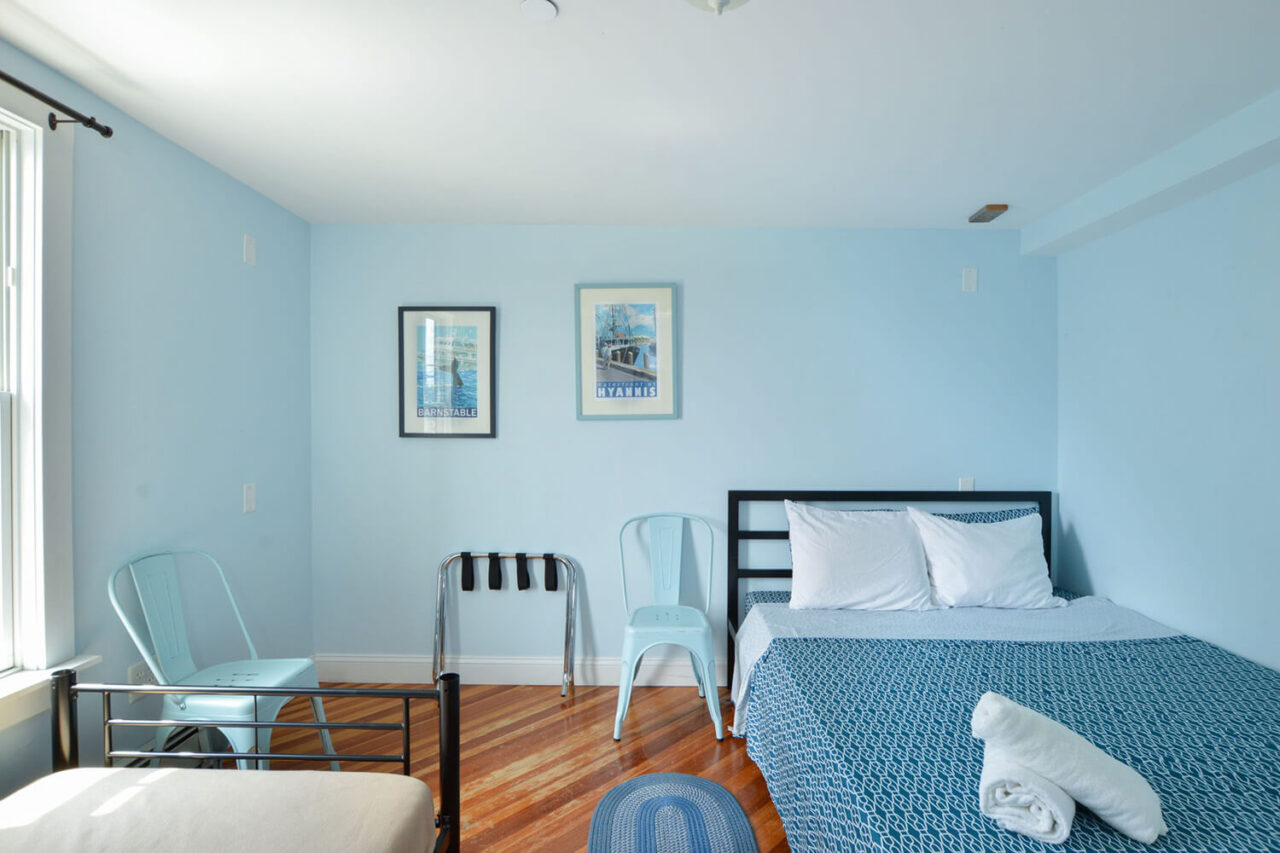 a private room at HI Hyannis hostel on cape cod. There is one freshly made queen-sized bed and one freshly made twin-sized bed.