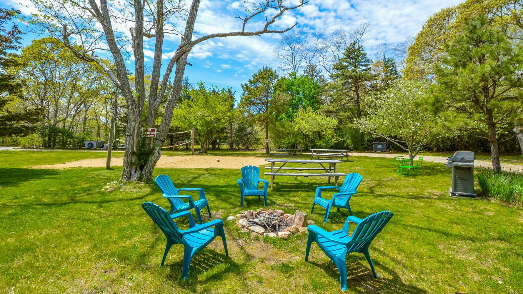 The front lawn at HI Martha's Vineyard hostel has a firepit with Adirondak chairs for guests