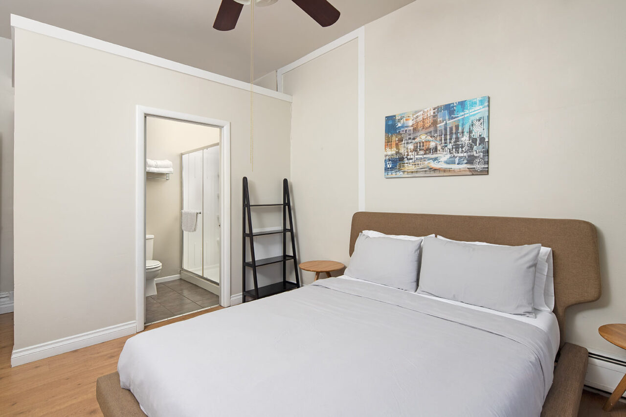 a private room at HI San Diego Downtown hostel with a freshly made full-sized bed and an ensuite bathroom