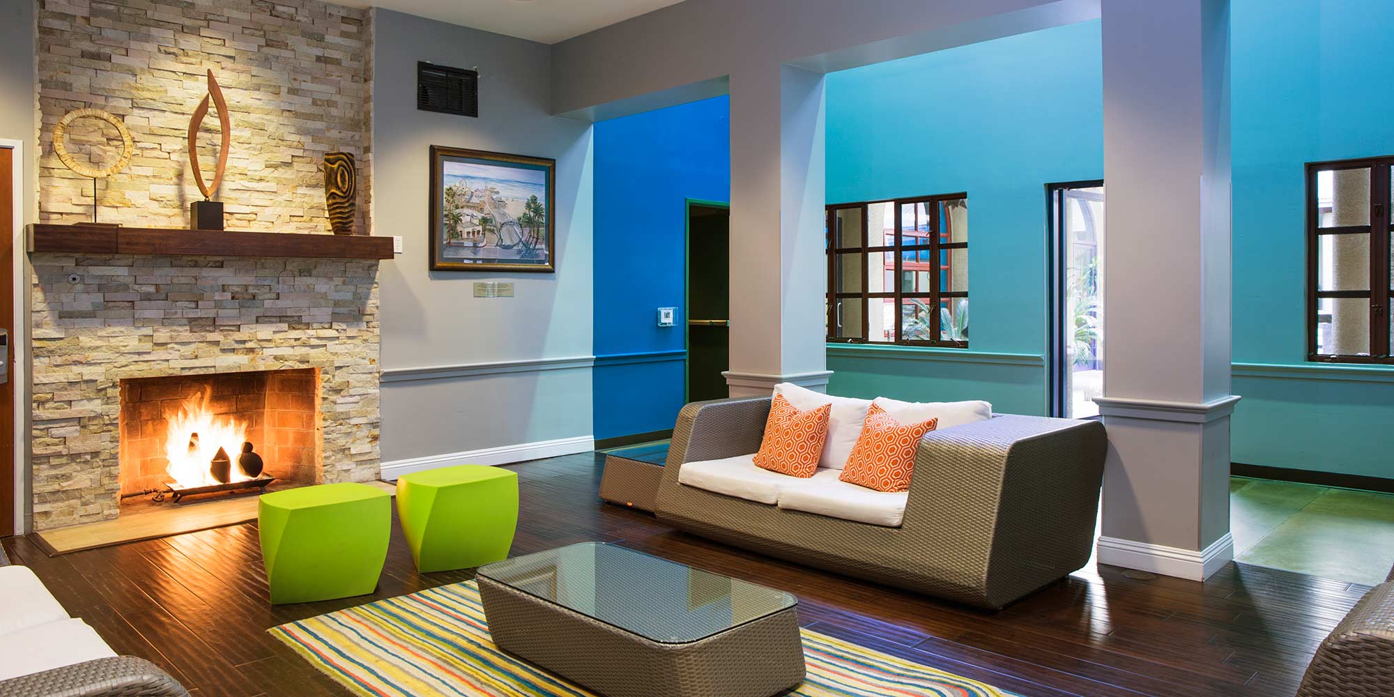 The guest lounge at HI Los Angeles Santa Monica is painted in vivid blue, with a stone fireplace and plenty of comfortable seating