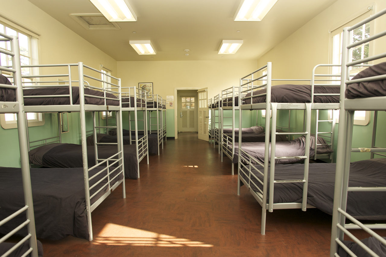a large room filled with clean twin-sized bunk beds