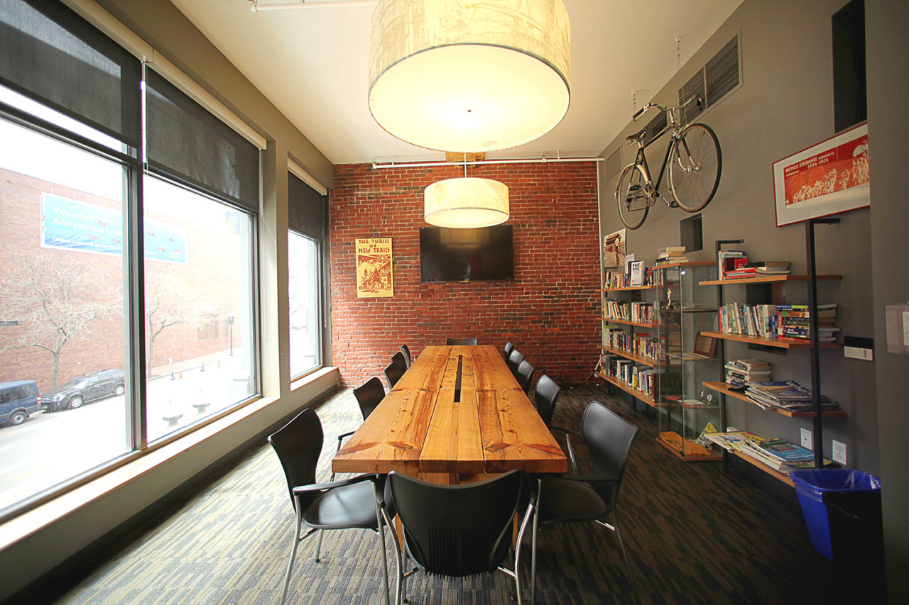 The library at HI Boston Hostel offers a quiet work or meeting space with ample seating at a long wood table