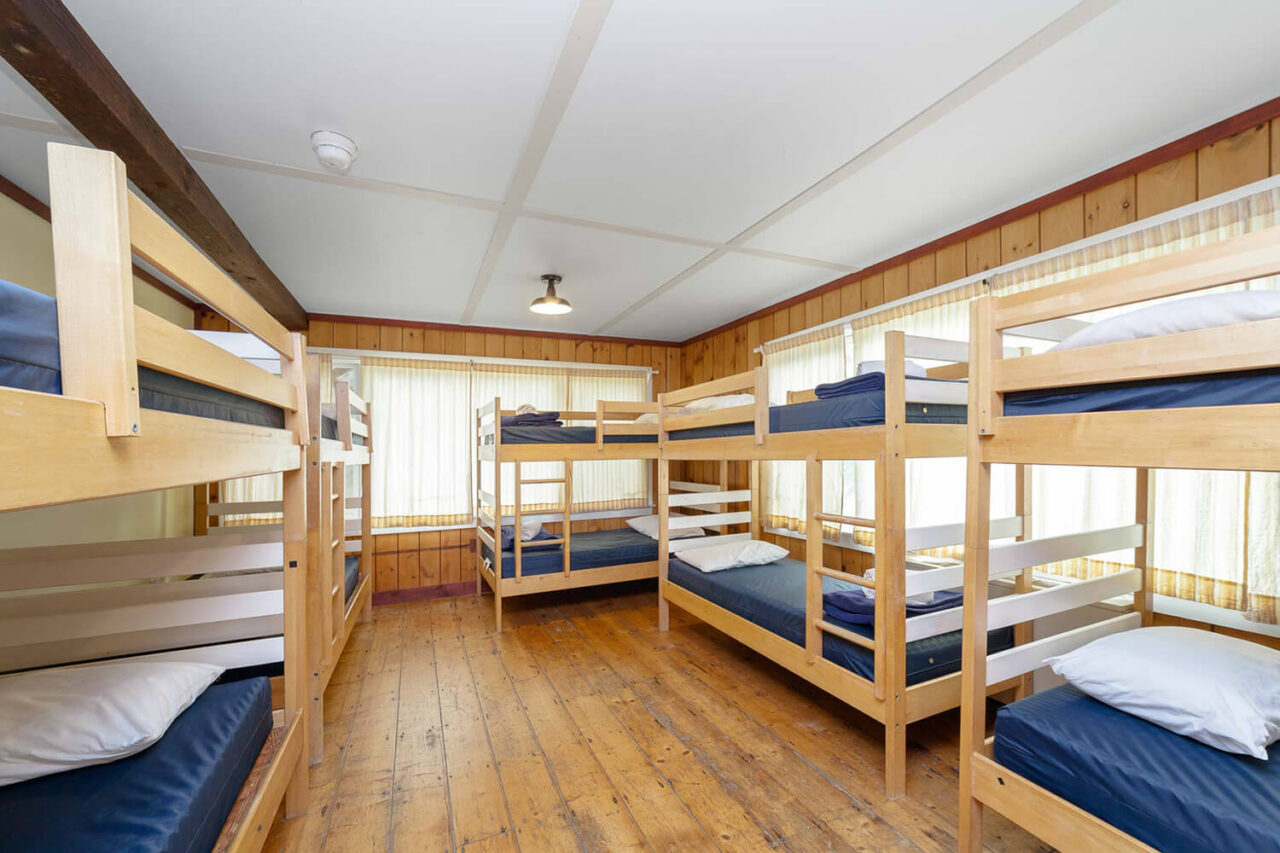 a bright and clean dorm room at HI Martha's Vineyard hostel with five sets of twin-sized bunks