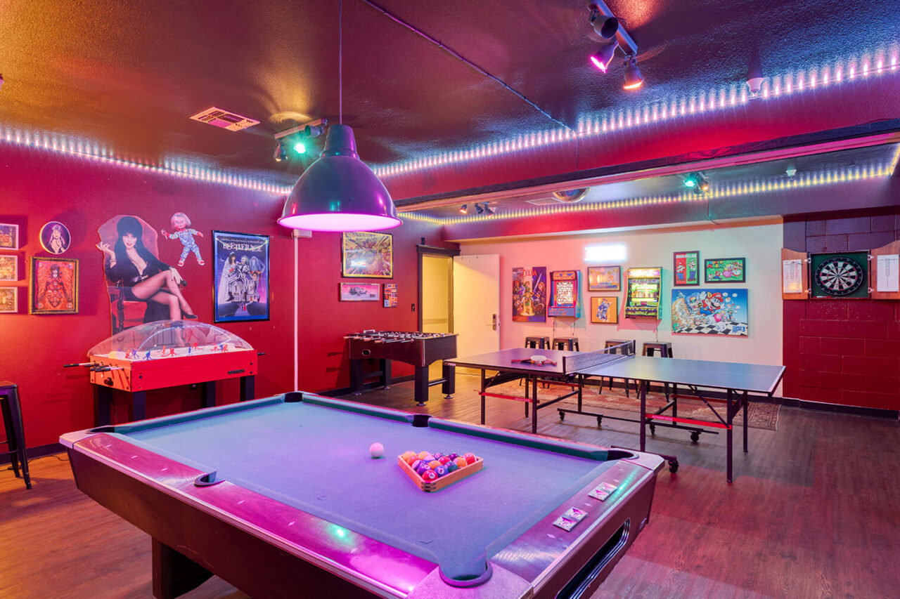 The retro arcade game room at HI Sacramento hostel has video games, a pool table, foosball, and ping pong
