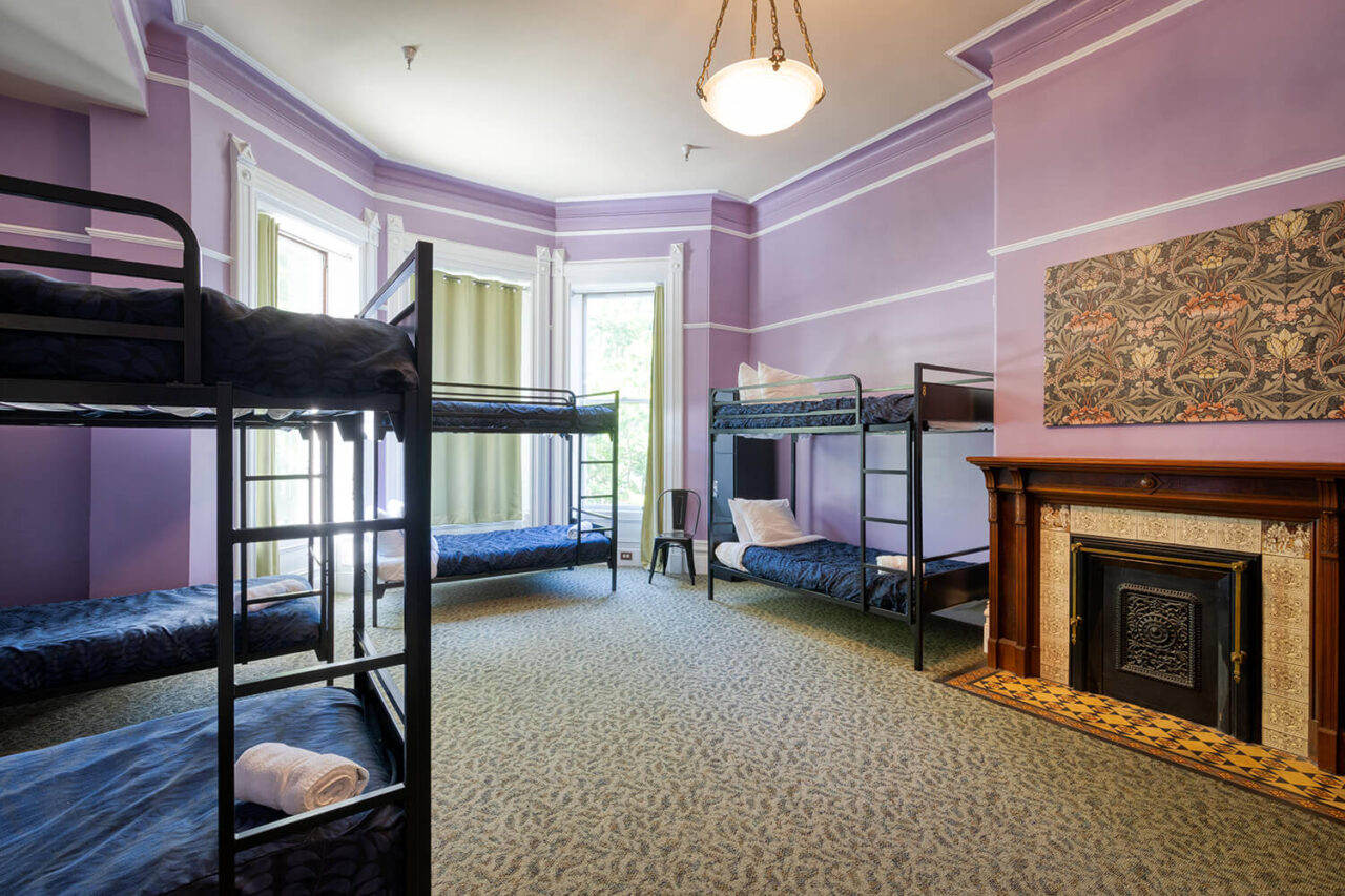 a bright and airy dorm room at HI Sacramento hostel with comfortable bunk beds and Victorian details