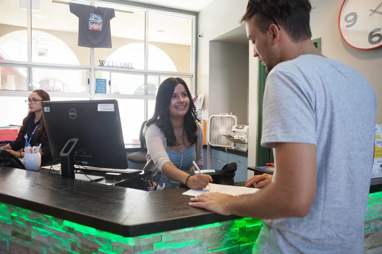 a man checks in at the front desk of a hostel