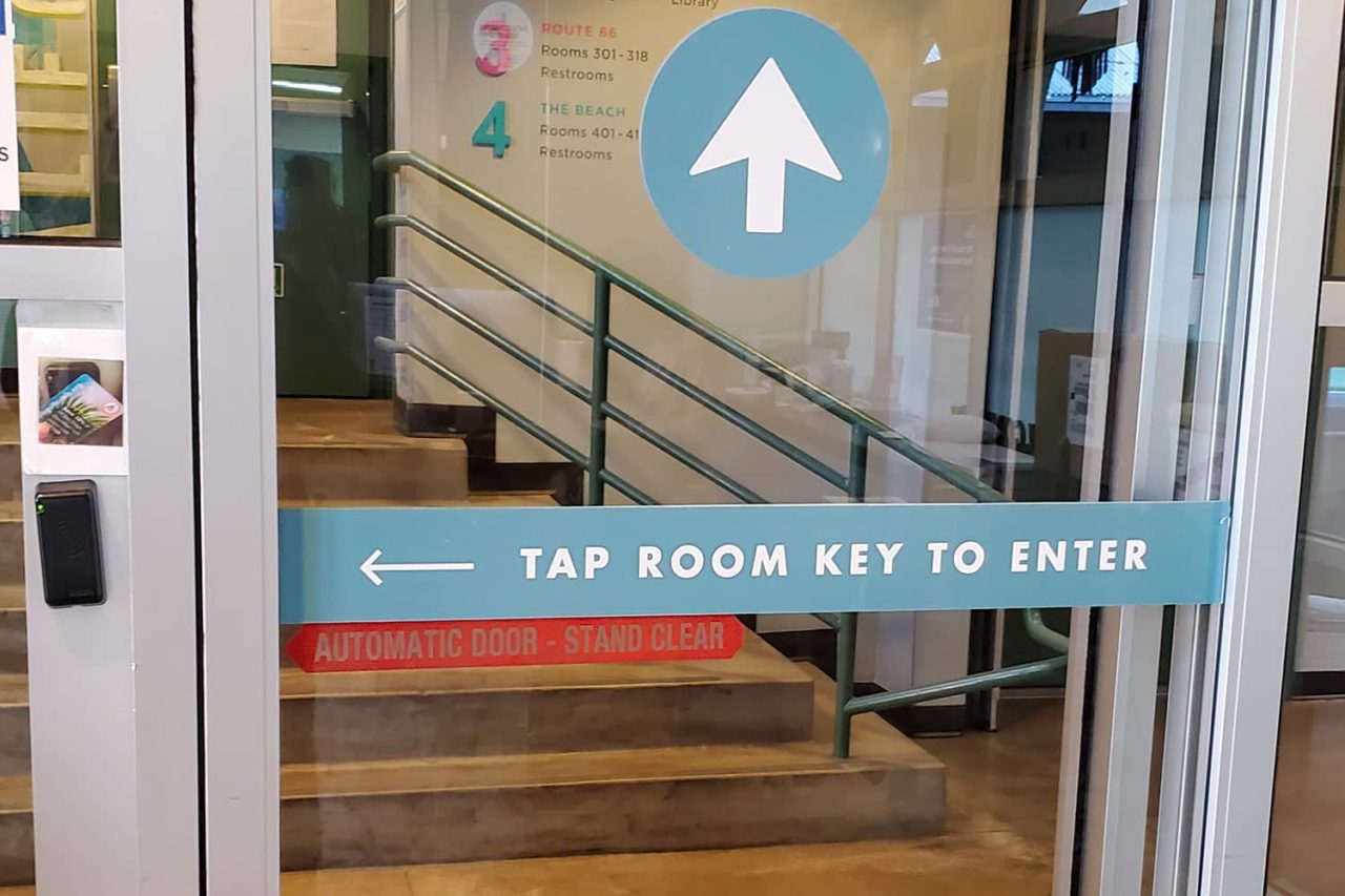 a secure sliding glass door in the lobby of HI Los Angeles Santa Monica hostel. At the side of the door, there is a place for registered guests to scan their individual keycards for secure entry into the hostel