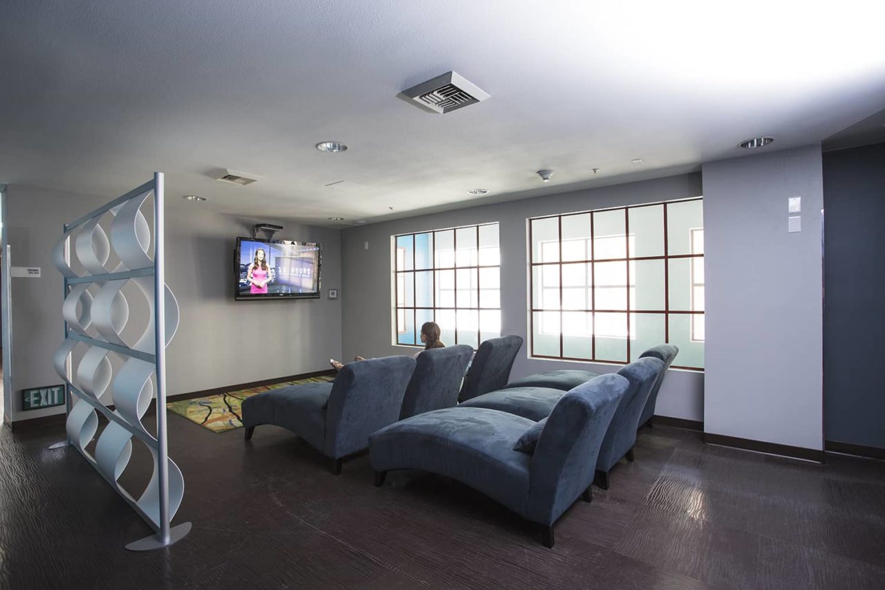 a large seating area in front of a large wall-mounted flat-screen TV