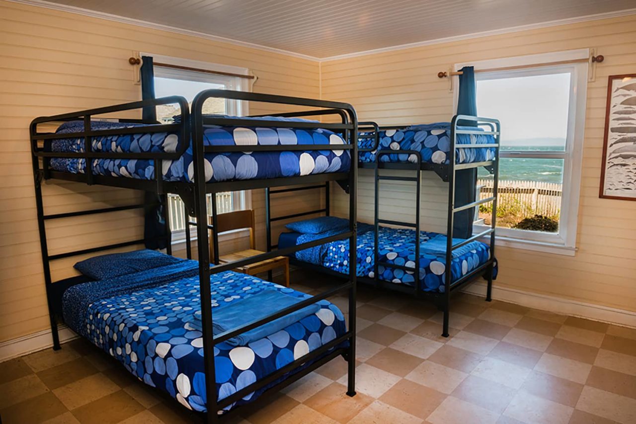 two sets of freshly made bunkbeds with blue bedspreads