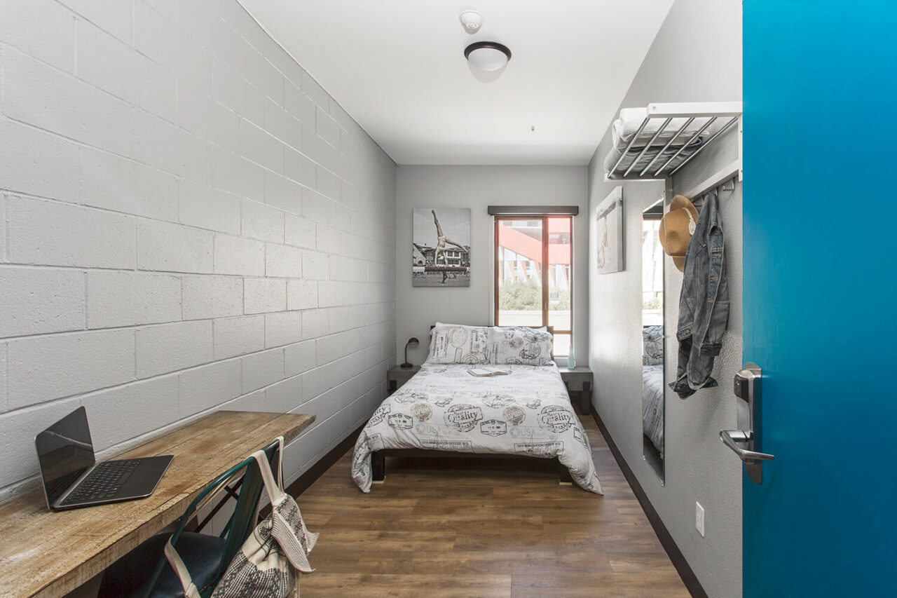a private room with one full-sized bed and a small desk and chair at HI Los Angeles Santa Monica hostel