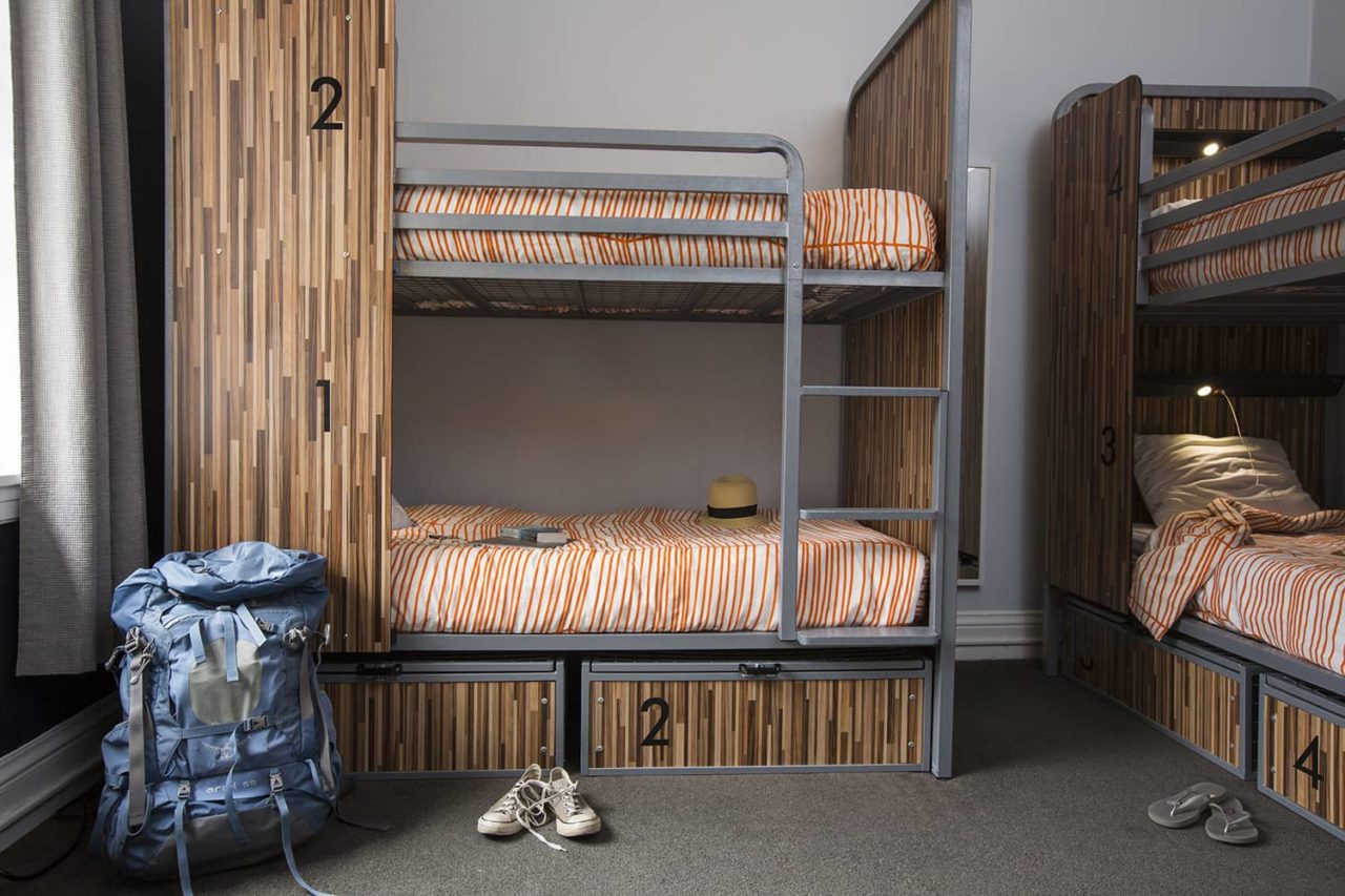 a backpack and pair of shoes in front of a set of bunkbeds in a dorm at HI San Francisco Downtown hostel