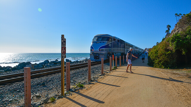 An Amtrak train in Southern California coasts along the ocean