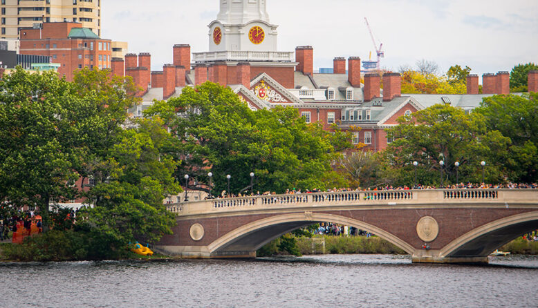 a bridge spanning the Charles River in Boston with Harvard University in the background
