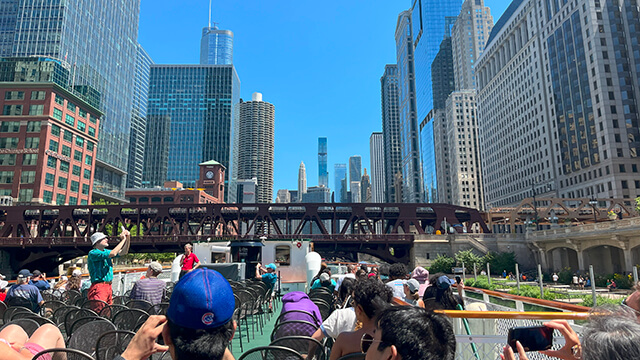 a group of people on a boat on the Chicago river looking up at skyscrapers