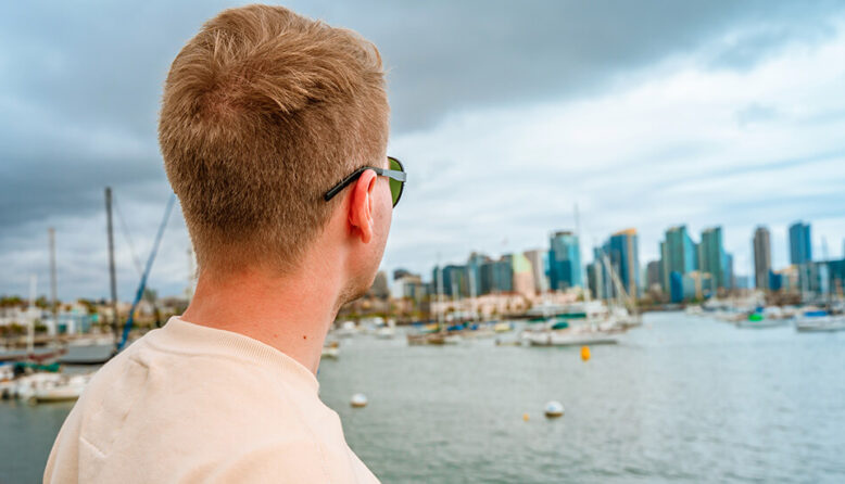 a young man looks out over the San Diego skyline