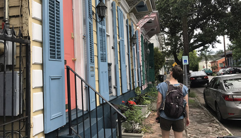 Woman in front of a row of colorful houses