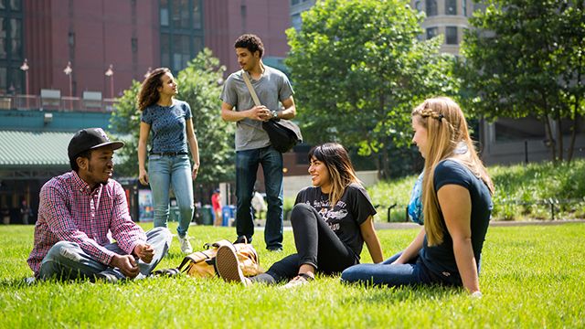 A group of people sitting on some grass