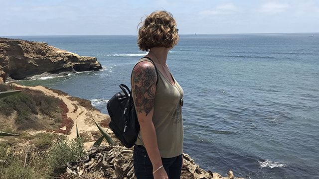 woman looking over the ocean at sunset cliffs San Diego