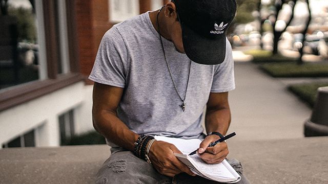 man writing in a journal