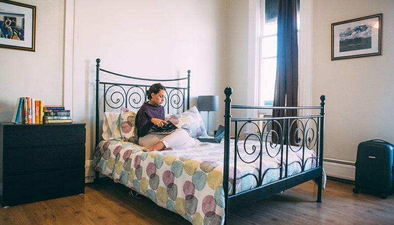 woman sitting on a bed in a private room at a hostel