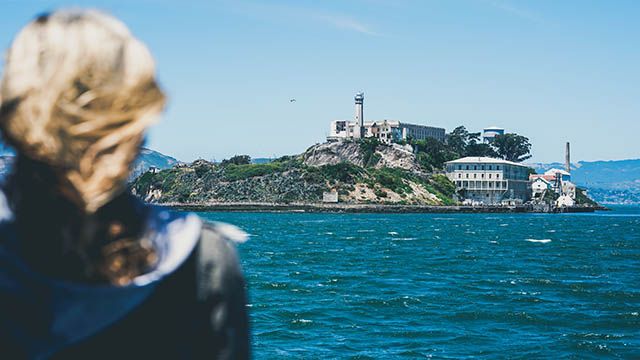 a woman looking at alcatraz island from the ferry