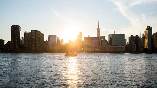 a view of Manhattan from the East River at sunset