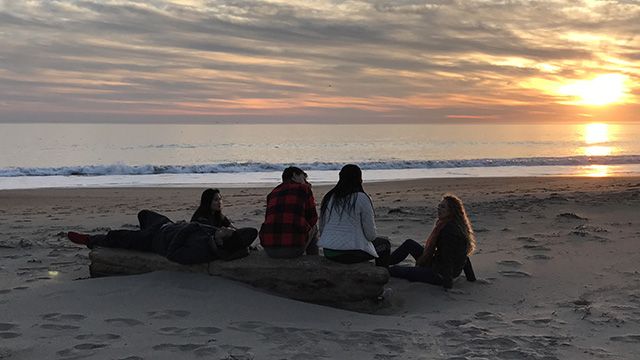 a group of travelers at Limantour Beach at sunset