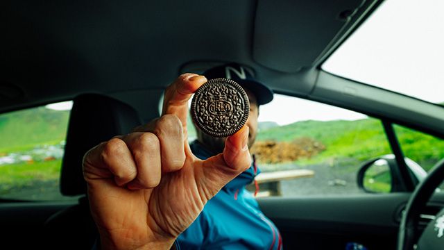 a man holding a cookie on a road trip
