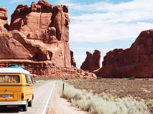 a van drives through arches national park