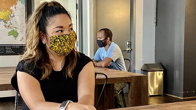 hostel guests wearing masks in a hostel lounge