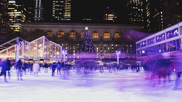 people ice skating at the ice rink in NYC's Bryant Park