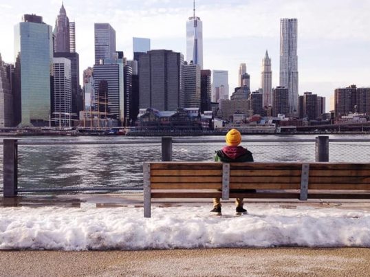 a person looking at the NYC skyline in the snow