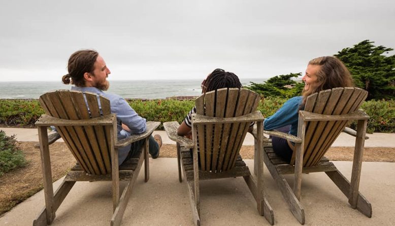 travelers relaxing in adirondack chairs at HI Pigeon Point Lighthouse