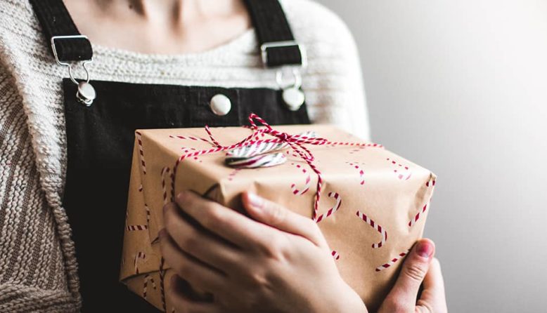 a woman holding a holiday gift