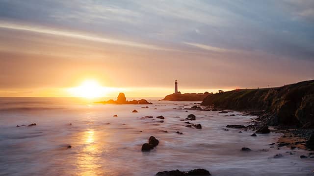 the sun setting behind pigeon point light house