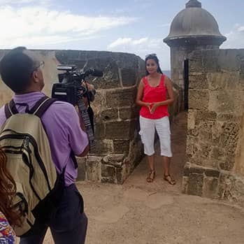 journalist Tinabeth Pina being filmed by a camera operator in Puerto Rico