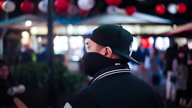 man in a mask walking through Little Tokyo in Los Angeles