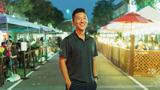 a man stands in the middle of a street full of outdoor dining parklets