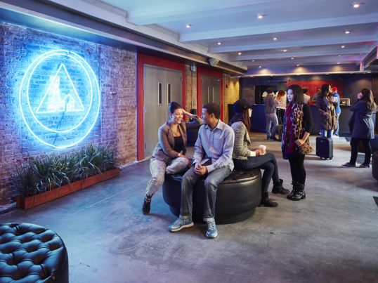 guests sit and talk in the lobby of HI NYC hostel
