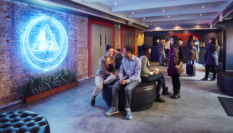 guests sit and talk in the lobby of HI NYC hostel