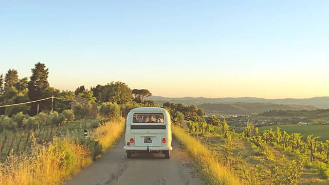 a van driving down a road with yellow flowers