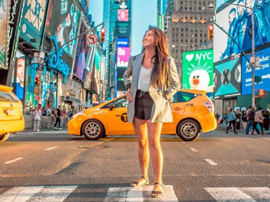 a woman stands in times square in new york city