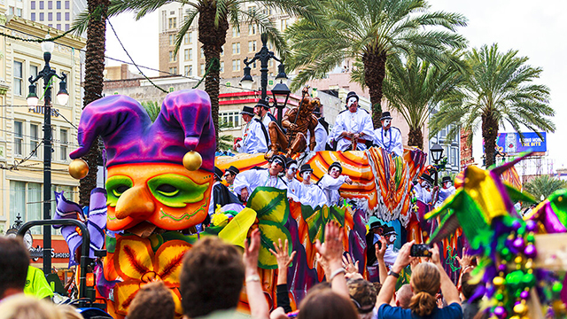 a colorful float going down the street during Mardi Gras in New Orleans