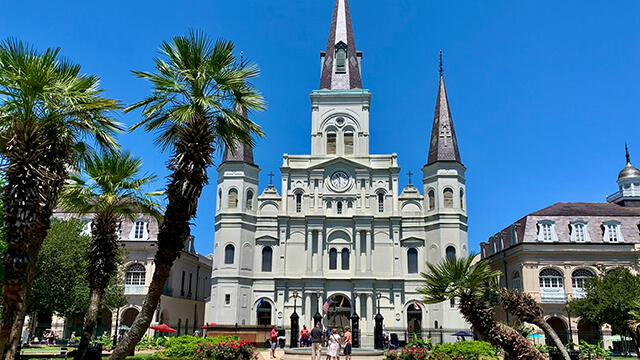 a tall, beautiful cathedral against a blue sky in New Orleans' Jackson Square