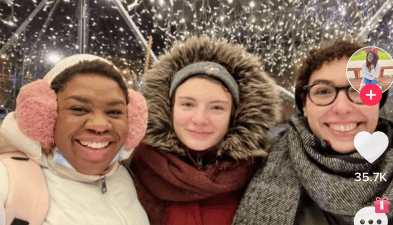 The author poses with two new friends in the falling snow. All three women are wearing heavy winter gear.