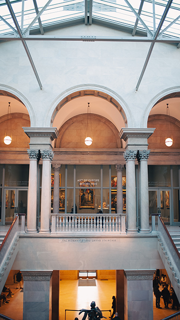 an interior view of a museum with columns and archways