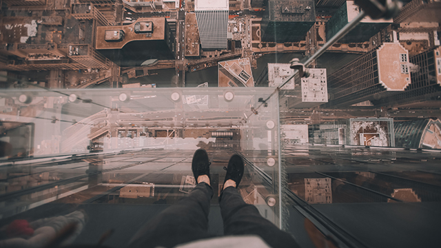 an overhead view of tall buildings from a person standing inside a transparent box