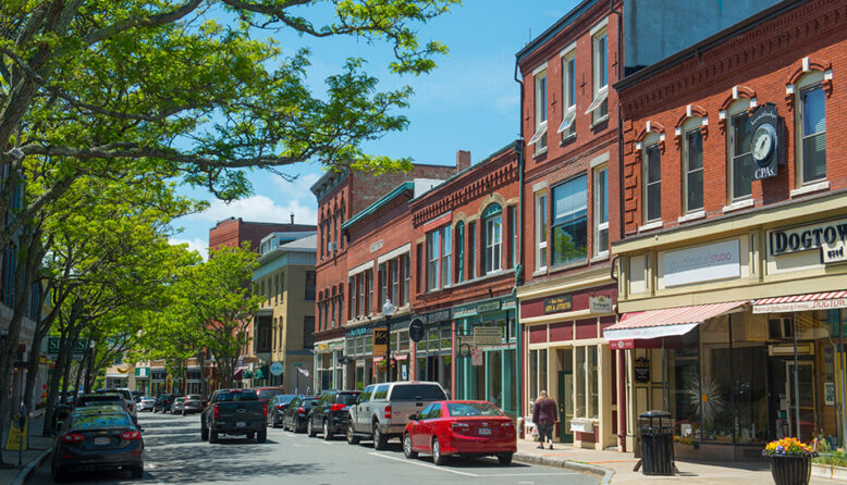 Gloucester Massachusetts' main street, lined with historic brick buildings and leafy green trees